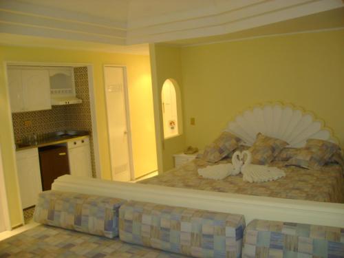 a bedroom with a bed with two swans on it at Hotel Las Torres Gemelas Acapulco in Acapulco
