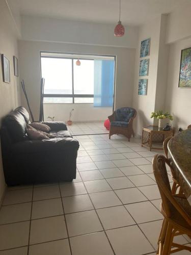 a living room with a couch on a tiled floor at Apartamento Vista al Mar in Porlamar