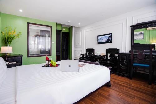 a bedroom with a white bed with a laptop on it at Sena Boutique Hotel & Travel in Hanoi