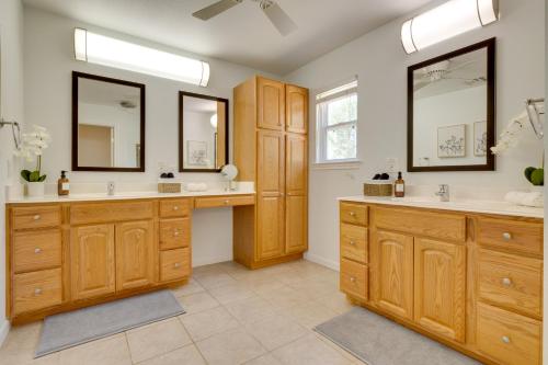 a bathroom with two sinks and two mirrors at 1-Story Hill Country Home Near Fiesta with Pool! in San Antonio