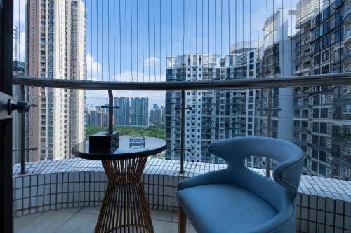 a balcony with a table and a chair and a window at Orange Tree International Hotel Zhujiang New Town Huacheng Sqaure Branch - Free Shuttle Bus to Canton Fair Complex During Canton Fair Period in Guangzhou