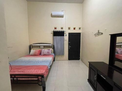 a small bedroom with two beds and a window at OYO Life 93032 Maju Mapan Homestay Syariah in Lamongan