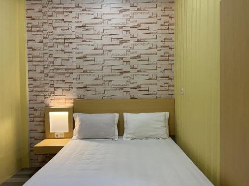 Posto letto in camera con muro di mattoni di OYO 93052 Batodupi Guesthouse Syariah 