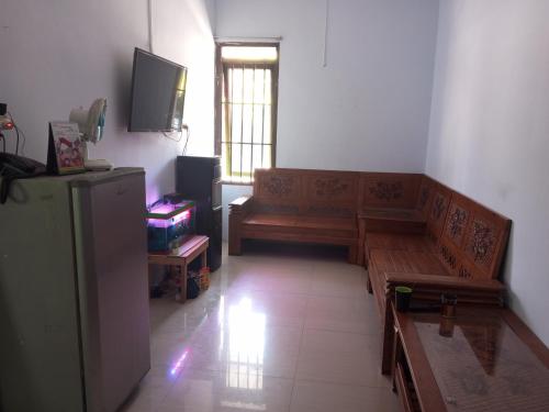a living room with a couch and a television at OYO 93012 Griya Kencana Asri Syariah in Lawean