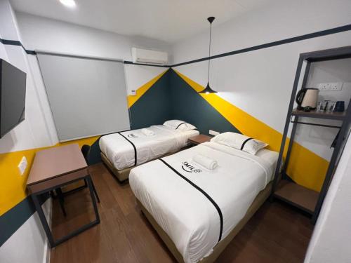 a small room with two beds and a table at Seeds Hotel Chow Kit in Kuala Lumpur