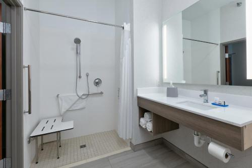 y baño blanco con lavabo y ducha. en Holiday Inn Express Hotel & Suites Shakopee, an IHG Hotel, en Shakopee