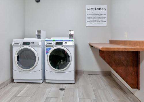 two washing machines and a counter in a laundry room at Holiday Inn Express Hotel & Suites Shakopee by IHG in Shakopee