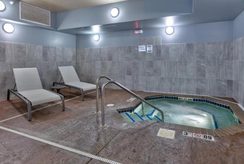 a hot tub in a waiting room with two chairs at Holiday Inn Express Hotel & Suites Shakopee by IHG in Shakopee
