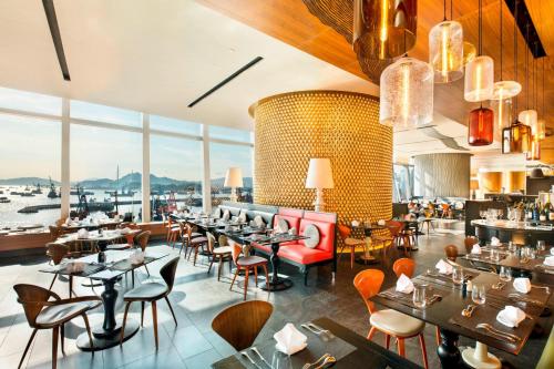 a restaurant with tables and chairs and a large window at W Hong Kong in Hong Kong