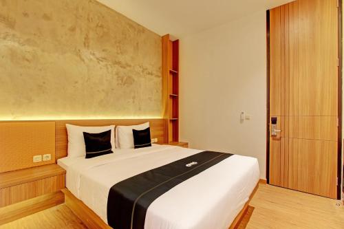 - une chambre avec un grand lit blanc et des oreillers noirs dans l'établissement Capital O 92987 Keenan Living Perumnas, à Yogyakarta