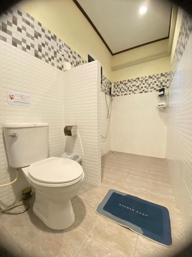 a bathroom with a toilet and a blue scale on the floor at Khao Sok River & Jungle Bungalow in Khao Sok