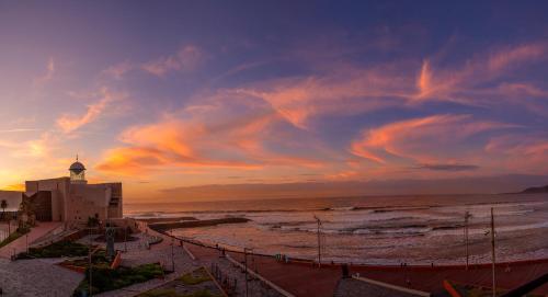 a view of a beach with a lighthouse and the ocean at Mirador Canteras-Auditorio in Las Palmas de Gran Canaria