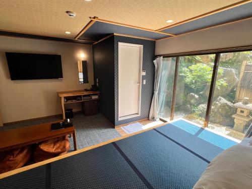 a room with a view of a bedroom with a large window at Onsen & Garden -Asante Inn- in Hakone