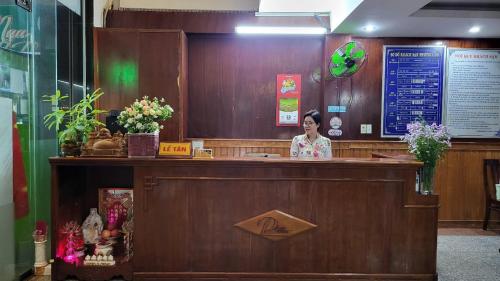 una mujer parada detrás de un bar en un restaurante en Khách Sạn Phương Lâm, en Dồng Xoài