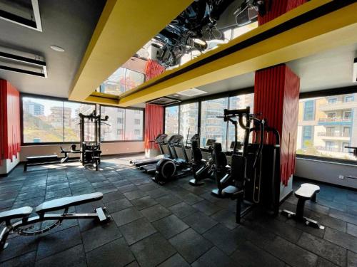 un gimnasio con cintas de correr y máquinas en una habitación con ventanas en Квартира в прекрасном комплексе en Mahmutlar
