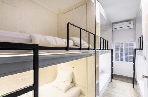 two bunk beds in a room with a bathroom at Comfy Crib Hostel in Bangkok