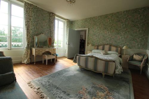 Schlafzimmer mit einem Bett und einem Spiegel in der Unterkunft Manoir Angle in Blanzay-sur-Boutonne