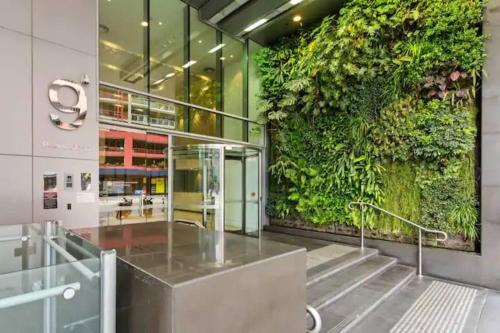 een lobby met een groene muur en een lift bij Prima Tower in Melbourne