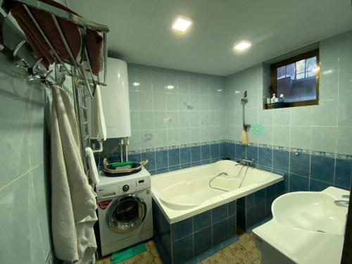 uma casa de banho com uma máquina de lavar roupa e um lavatório em My Hovli em Tashkent