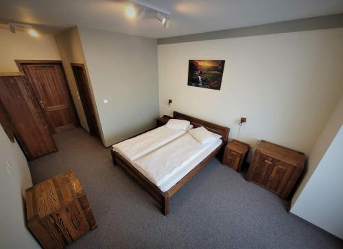 a bedroom with a bed and two wooden chests at Pensiunea Eden Éden Panzió in Odorheiu Secuiesc