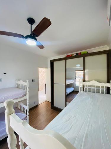 a bedroom with two bunk beds and a ceiling fan at Casa com piscina e jacuzzi in Cabo Frio