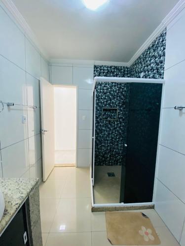 a bathroom with a shower with a glass door at Casa com piscina e jacuzzi in Cabo Frio