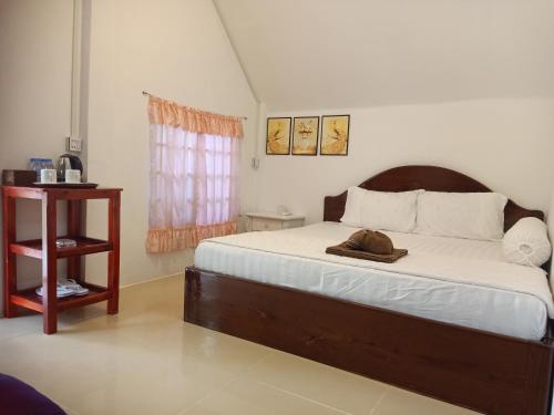 una camera da letto con un letto con un cappello sopra di Bunnan Bungalows and Restaurant a Koh Rong Island