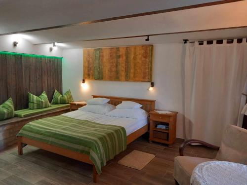um quarto com uma cama grande e um cobertor verde em Őshaza Vendégház em Bazsi