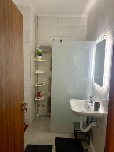 a small bathroom with a sink and a window at Apartman Mančić in Pirot