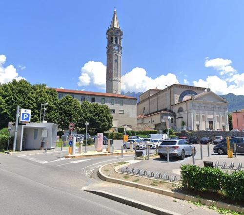 a parking lot with a large building with a clock tower at Casa Imbarcadero in Lecco