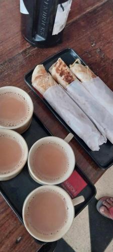 a tray with slices of pizza on a table with plates at Packbag Comfort Bed & Breakfast in Kovalam