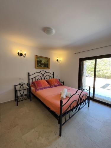 - une chambre dotée d'un grand lit avec des draps orange dans l'établissement Villa Campana - Sartène, à Sartène