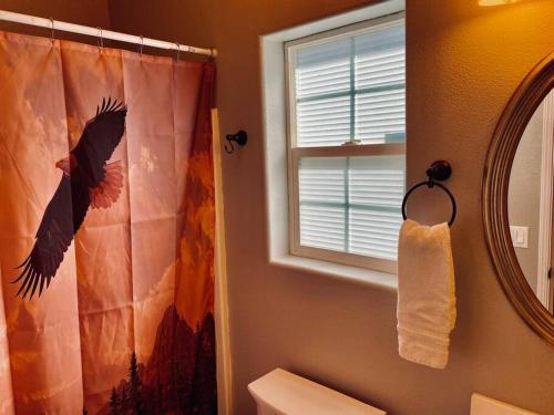 La salle de bains est pourvue d'un rideau de douche et d'un miroir. dans l'établissement Eagle Nest River Views Hot Tub Games Sleeps 6, à Ahwahnee