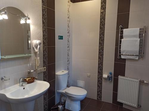 a bathroom with a toilet and a sink at Hotel Status in Vinnytsya