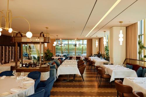 a dining room with white tables and chairs at Crowne Plaza Belgrade by IHG in Belgrade