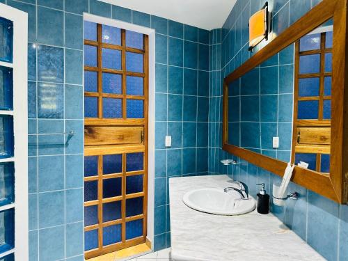 Baño azul con lavabo y espejo en Aissatou Beach Resort en Boracay