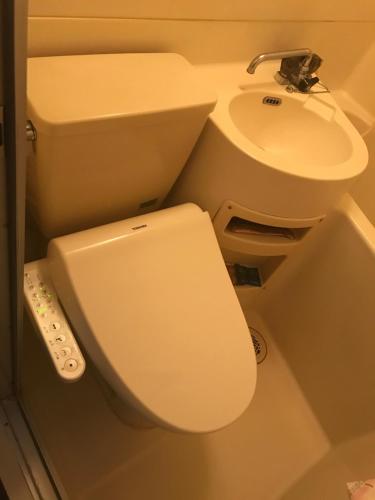a bathroom with a toilet and a sink at 大阪長居港湾客房 in Osaka