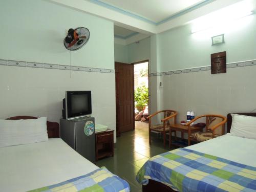 ein Hotelzimmer mit 2 Betten und einem TV in der Unterkunft Kathy Hotel in Phan Thiet
