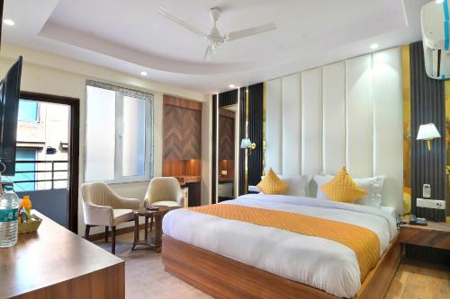 a hotel room with a large bed and a desk at The Saina International Delhi - By La Exito Hotels in New Delhi