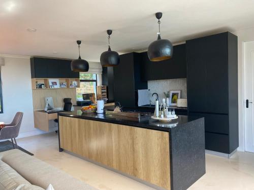 a kitchen with black cabinets and a counter top at Constantia View Apartments- Luxury Self Catering in Cape Town