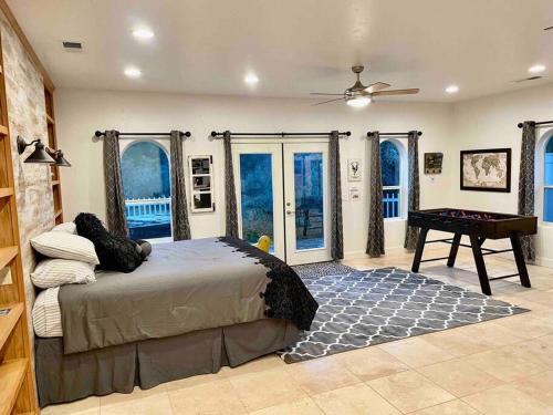 a bedroom with a bed and a table and windows at The Funky Chicken Hot Tub BBQ SLEEPS 4 in Ahwahnee