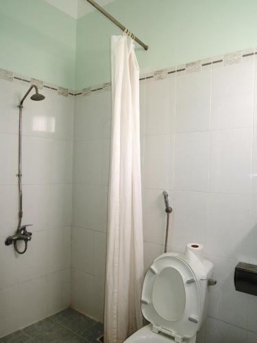 a bathroom with a toilet with a shower curtain at Kathy Hotel in Phan Thiet