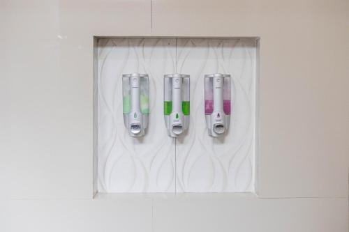 four cell phones are hanging on a wall at Mandhasativa Homestay in Singaraja
