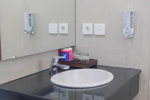 a bathroom with a sink and a mirror at Mandhasativa Homestay in Singaraja
