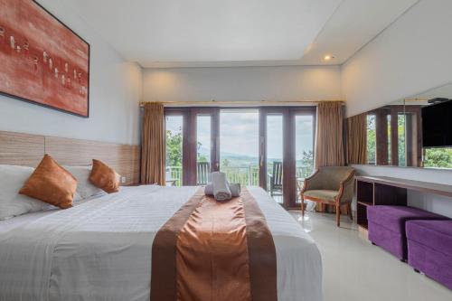 a bedroom with a large bed with a large window at Mandhasativa Homestay in Singaraja