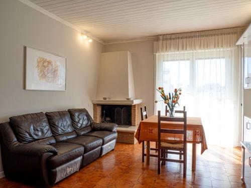 a living room with a leather couch and a table at Casa Verdi Colli in Montecastrilli