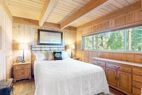 a bedroom with a bed in a wooden room at Fernwood in Shaver Lake