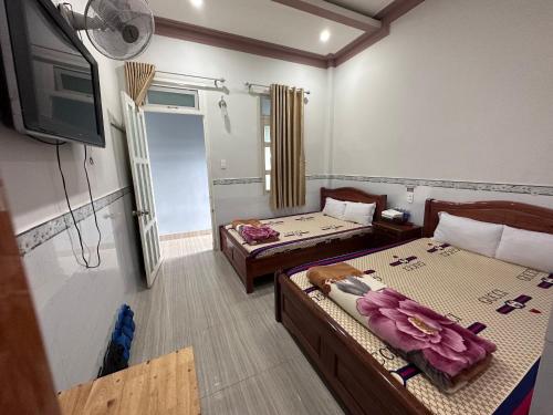 a hotel room with two beds and a tv at Motel Khánh Vy in Bao Loc