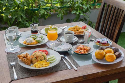 a wooden table with plates of food on it at Mandhasativa Homestay in Singaraja