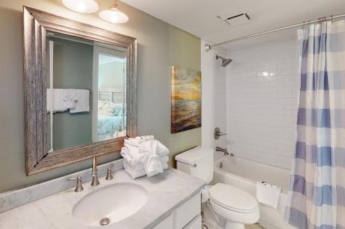a bathroom with a sink and a toilet and a mirror at Phoenix East II 2022 in Orange Beach